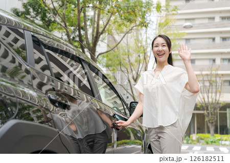 車から降りる笑顔の若い女性 126182511