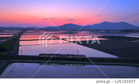 越後平野の水田に映る夕焼けと電車 126183937