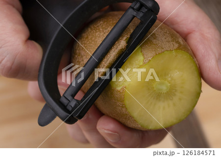 ゴールドキウイフルーツの皮をピーラーで剥く 126184571