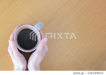 コーヒーを飲む女性の手元 126184833