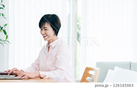 リモートワークをする中高年女性 リモートワークをする中高年女性 126185003