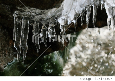並んだツララから落ちる球しずく 126185307