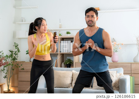 Young asian couple workout during woman hold smartphone encouragement to partner. Young asian couple workout during woman hold smartphone encouragement to partner. 126186615