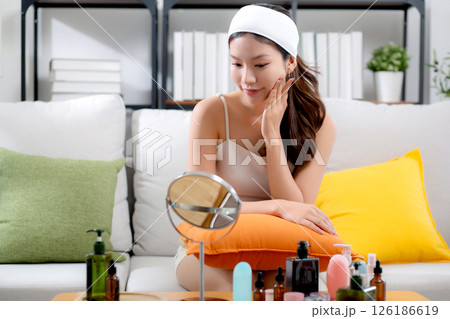 Beauty young asian woman looking mirror for check wrinkles on facial in living room. Beauty young asian woman looking mirror for check wrinkles on facial in living room. 126186619