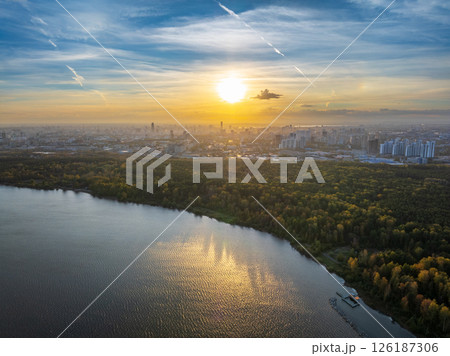 Autumn forest on lake shore at sunset and city on horizon, auerial view 126187306