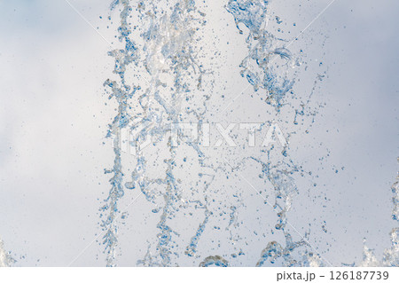 Splashes and jets of water against light background. Splashes and jets of water against light background. 126187739