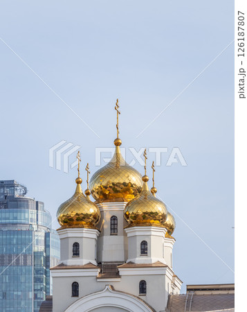 The golden domes of the Christian church in sunset light. 126187807