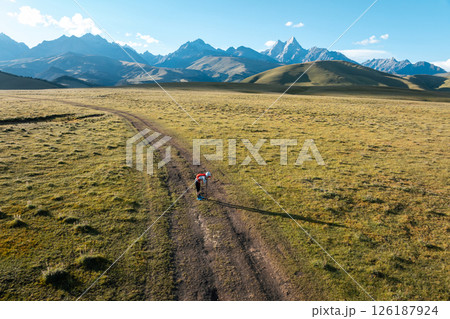 Aerial view of woman trail runner in high altitude mountains 126187924