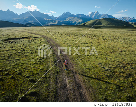 Aerial view of woman trail runner in high altitude mountains Aerial view of woman trail runner in high altitude mountains 126187932