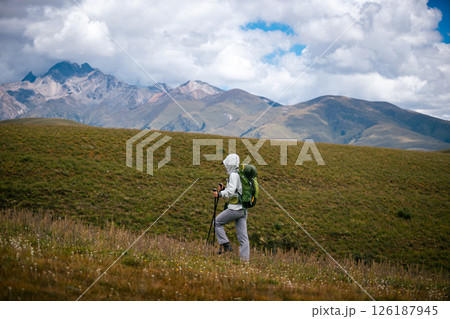 Woman backpacker hiking on high altitude mountains Woman backpacker hiking on high altitude mountains 126187945