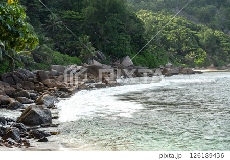 Scenic coastal view of La Digue Island, Seychelles, with a rocky shoreline, tropical palm trees Scenic coastal view of La Digue Island, Seychelles, with a rocky shoreline, tropical palm trees 126189436