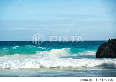 Huge dangerous waves crashing on the beautiful Seychelles beach, with powerful ocean surf Huge dangerous waves crashing on the beautiful Seychelles beach, with powerful ocean surf 126189450