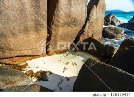 Massive granite boulders and white sand create a tropical beach landscape on La Digue island 126189454