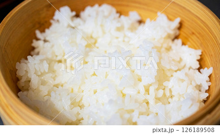 Japanese rice served in a bamboo bowl, with soft lighting highlighting the plump, moist rice grains, steamed Japanese rice, rice in bamboo bowl 126189508