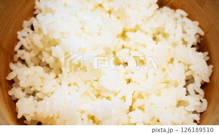 Japanese rice served in a bamboo bowl, with soft lighting highlighting the plump, moist rice grains, steamed Japanese rice, rice in bamboo bowl 126189510
