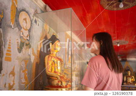 asian woman travel and see to gold buddha statue at chiangmai Thailand in summer season asian woman travel and see to gold buddha statue at chiangmai Thailand in summer season 126190378