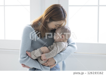 赤ちゃんを抱っこする可愛いママ 126193162