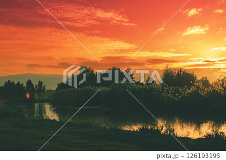 Silhouette of the mountain against the sunset sky. Beautiful lake against mountains. The Hula Valley in northern Israel at sunset Silhouette of the mountain against the sunset sky. Beautiful lake against mountains. The Hula Valley in northern Israel at sunset 126193195