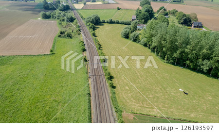 A stunning aerial view showcasing the train tracks that weave through the beautiful scenic fields 126193597