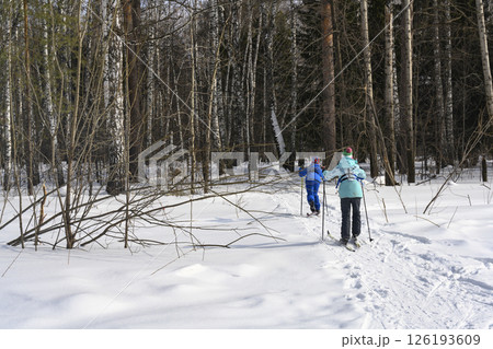 Children in orienteering classes run skiing in a snowy dense forest in winter 126193609