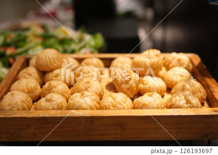 round choux pastries fluffy golden brown baked choux pastry on baking tray round choux pastries fluffy golden brown baked choux pastry on baking tray 126193697