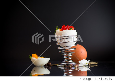 delicacy with red caviar and boiled egg for breakfast, isolated on black background. 126193915