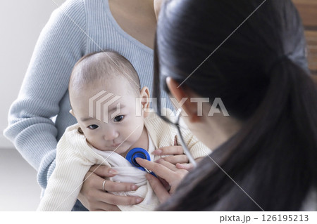 赤ちゃんを診察する女性医師 126195213