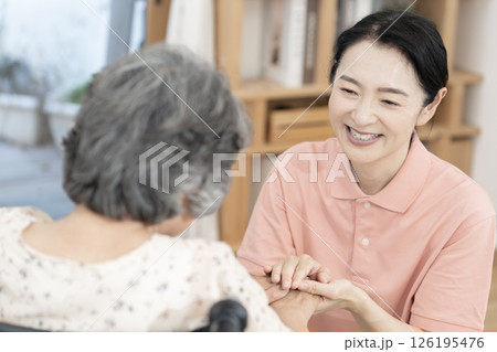 車椅子のシニア女性と話をする女性介護士 車椅子のシニア女性と話をする女性介護士 126195476