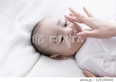 赤ちゃんにクリームを塗るママの手 赤ちゃんにクリームを塗るママの手 126195688