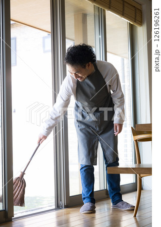 掃除を箒でする丁寧な暮らしの男性　田舎や地方移住などリタイアやfire後のライフスタイル 126196261