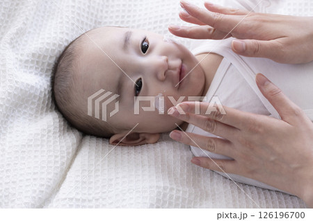赤ちゃんにクリームを塗るママの手 126196700