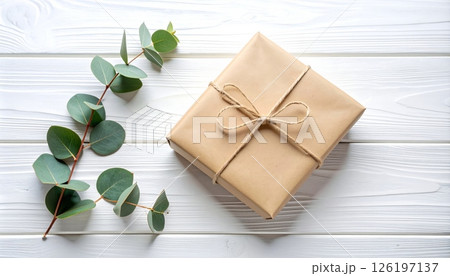 Rustic Paper Gift with Eucalyptus Sprig on White Wood Rustic Paper Gift with Eucalyptus Sprig on White Wood 126197137