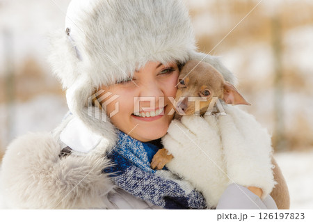 Woman playing with dog during winter Woman playing with dog during winter 126197823