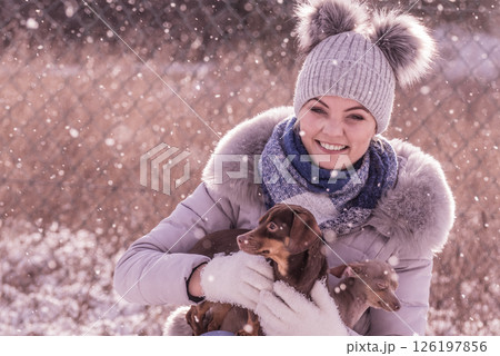 Woman playing with dogs during winter 126197856