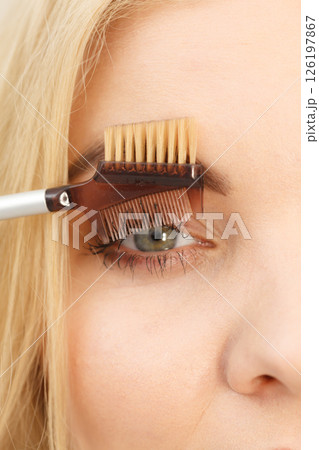 Woman brushing her eyelashes 126197867