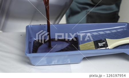 A person skillfully mixes red paint in a blue tray for art. Creative 126197954