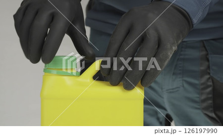 A man's hand opens a yellow bottle. Creative A man's hand opens a yellow bottle. Creative 126197990