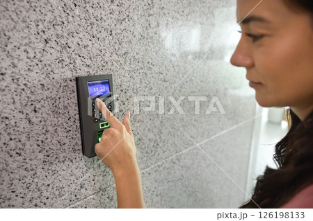 Closeup young woman pressing buttons on smart electronic alarm system Closeup young woman pressing buttons on smart electronic alarm system 126198133