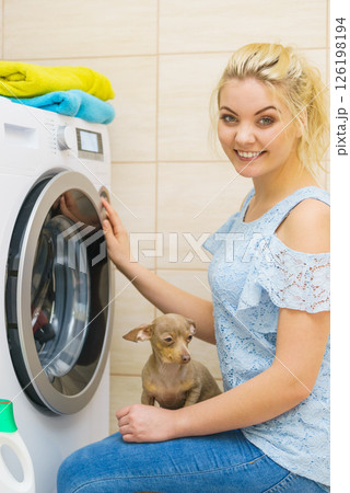 Woman setting washing machine Woman setting washing machine 126198194