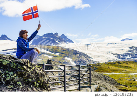 Tourist with norwegian flag in mountains 126198238