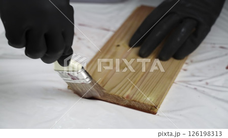 Meticulously Painting a Wooden Surface with Careful Attention to Detail and Protection. Creative Meticulously Painting a Wooden Surface with Careful Attention to Detail and Protection. Creative 126198313