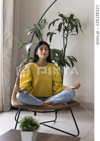 Millennial woman relax by meditation sit on chair cross legged 126198321