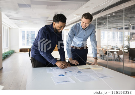 Two young professional teammates analyzing business data 126198358