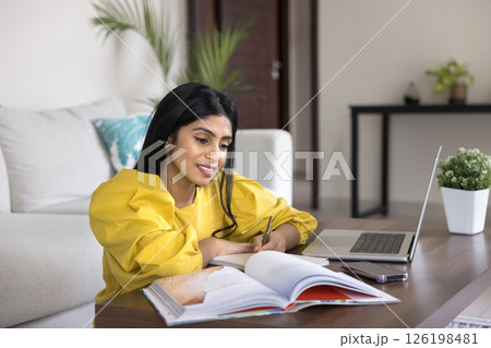 Millennial girl student use books notebook to study at home Millennial girl student use books notebook to study at home 126198481