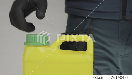 A man opens a yellow container with a green lid, revealing its contents. Creative A man opens a yellow container with a green lid, revealing its contents. Creative 126198488