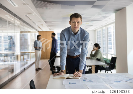 Portrait of young man, project manager reviewing documentation 126198588