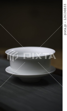 Aesthetic and Elegant White Porcelain Bowls Perfectly Stacked on a Beautiful Wooden Surface. Media 126198633
