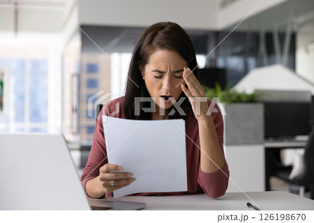 Nervous young woman check project documents frustrated with unexpected mistakes 126198670