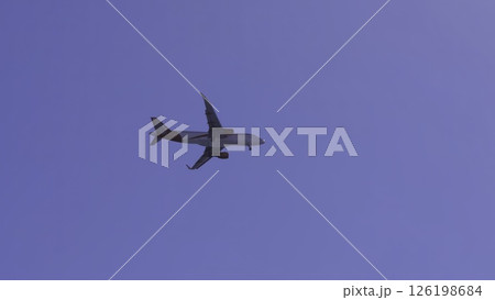 Passenger airplane flying and turning in blue sky. Action 126198684
