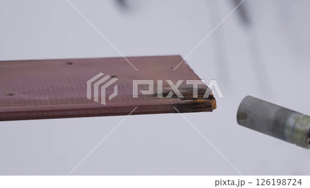 An experienced specialist demonstrates the technique of wood processing using fire. Creative An experienced specialist demonstrates the technique of wood processing using fire. Creative 126198724